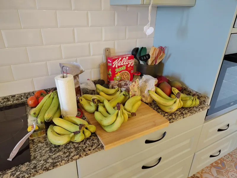 A kitchen with white tile backsplash and brown marble counter that has 8 bunches...