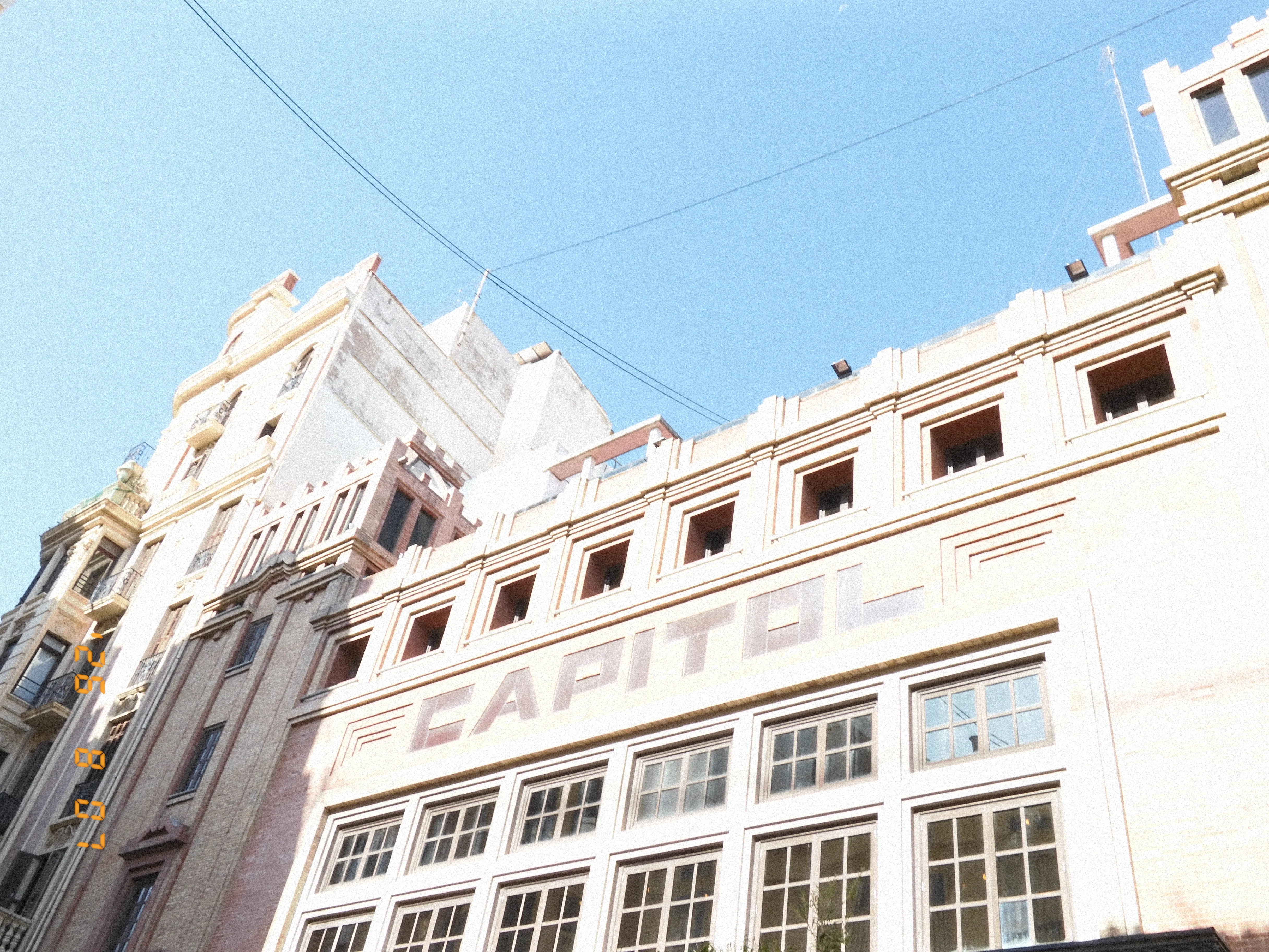 A large, white, art-deco style building with the word "capitol" across the front
